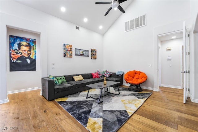 living room with high vaulted ceiling, ceiling fan, visible vents, and light wood finished floors