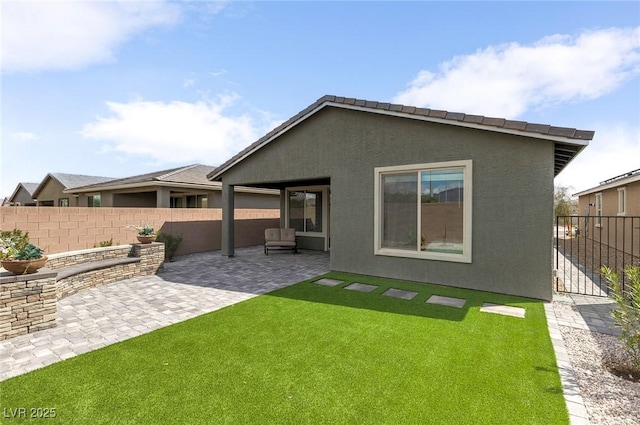 2114 Cold Canyon Ave, North Las Vegas, NV 89086 - back of house with a fenced backyard, stucco siding, a yard, and a patio area