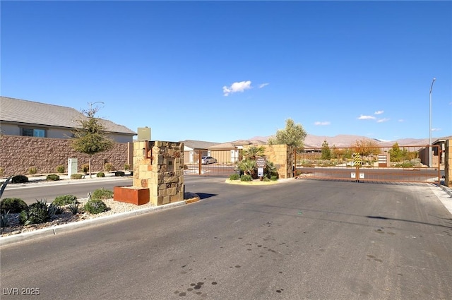2114 Cold Canyon Ave, North Las Vegas, NV 89086 - view of road with a gate, a mountain view, a gated entry, and curbs