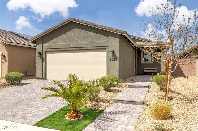 2114 Cold Canyon Ave, North Las Vegas, NV 89086 - view of front of house featuring a tiled roof, a garage, decorative driveway, and stucco siding