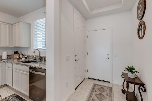 2114 Cold Canyon Ave, North Las Vegas, NV 89086 - kitchen featuring light tile patterned flooring, dishwasher, light stone countertops, a raised ceiling, and a sink