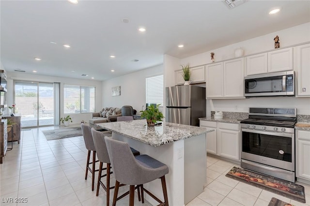2114 Cold Canyon Ave, North Las Vegas, NV 89086 - kitchen with light tile patterned flooring, recessed lighting, appliances with stainless steel finishes, open floor plan, and a center island