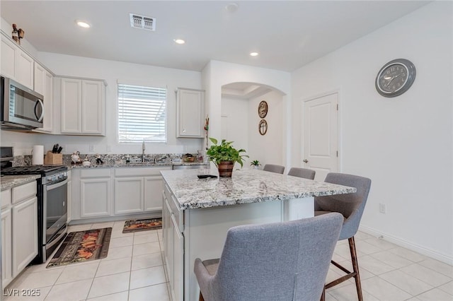 2114 Cold Canyon Ave, North Las Vegas, NV 89086 - kitchen featuring light tile patterned flooring, a breakfast bar area, a sink, and appliances with stainless steel finishes