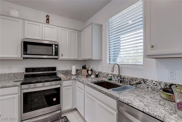 2114 Cold Canyon Ave, North Las Vegas, NV 89086 - kitchen with white cabinets, a sink, stainless steel appliances, and light stone counters