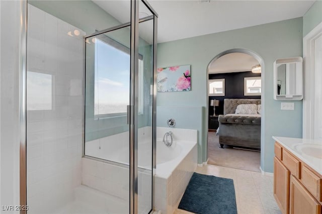 full bathroom with vanity, a garden tub, a shower stall, tile patterned flooring, and ensuite bath