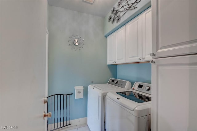 washroom with cabinet space, washing machine and dryer, and baseboards