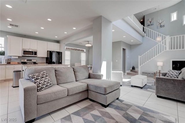 living room with visible vents, recessed lighting, stairway, and light tile patterned floors