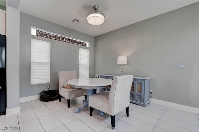 dining room featuring baseboards, visible vents, and light tile patterned floors
