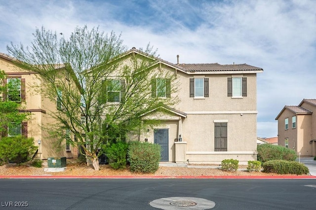 view of front facade with stucco siding and a tiled roof