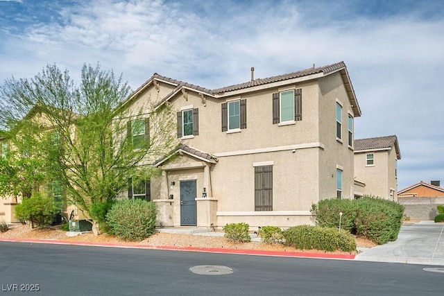 view of front of house with stucco siding and a tiled roof