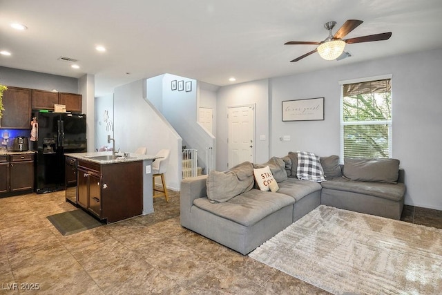living area with recessed lighting, ceiling fan, visible vents, and stairway