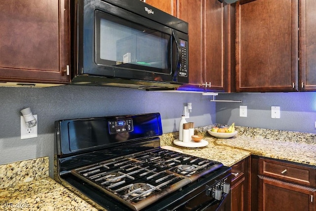 kitchen with black appliances and light stone counters