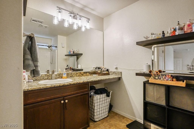 bathroom featuring tile patterned flooring, vanity, baseboards, and visible vents