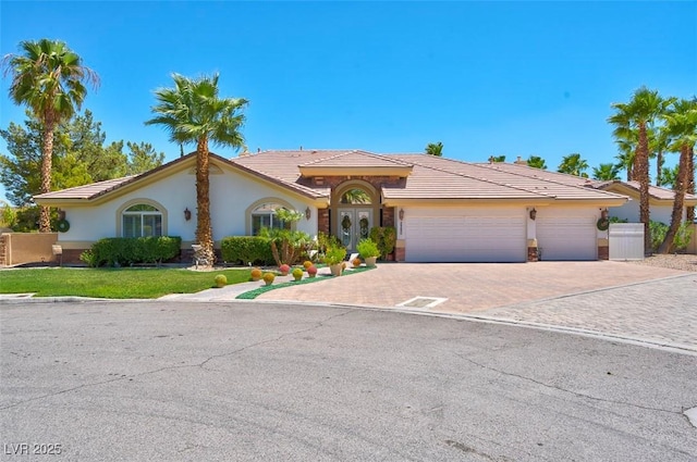 2290 Casa Bella Ct, Las Vegas, NV 89117 - view of front of home featuring decorative driveway, a garage, a tiled roof, and stucco siding