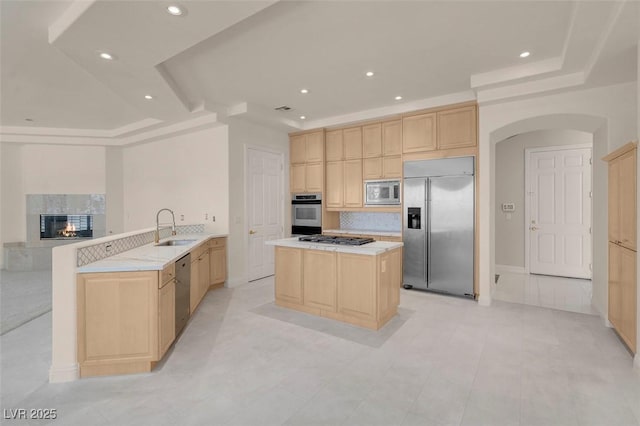 2290 Casa Bella Ct, Las Vegas, NV 89117 - kitchen featuring built in appliances, light brown cabinets, a tray ceiling, arched walkways, and backsplash