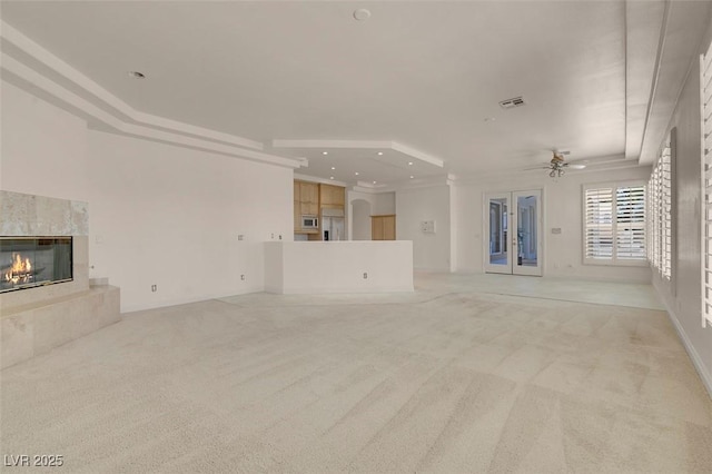 2290 Casa Bella Ct, Las Vegas, NV 89117 - unfurnished living room with light colored carpet, a ceiling fan, a premium fireplace, recessed lighting, and french doors