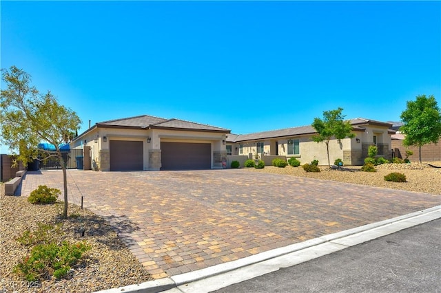 9511 Star Vista Ct, Las Vegas, NV 89149 - view of front facade with a garage, stucco siding, fence, decorative driveway, and stone siding