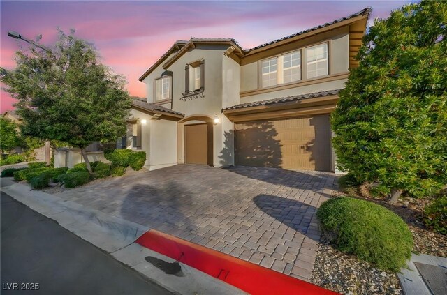 12283 Lost Treasure Ave, Las Vegas, NV 89138 - mediterranean / spanish-style house with an attached garage, decorative driveway, stucco siding, and a tile roof