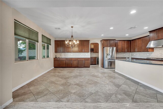 12283 Lost Treasure Ave, Las Vegas, NV 89138 - kitchen featuring backsplash, arched walkways, appliances with stainless steel finishes, and under cabinet range hood