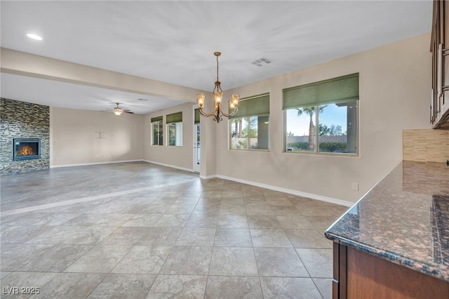 12283 Lost Treasure Ave, Las Vegas, NV 89138 - unfurnished dining area with baseboards, visible vents, a large fireplace, and ceiling fan with notable chandelier