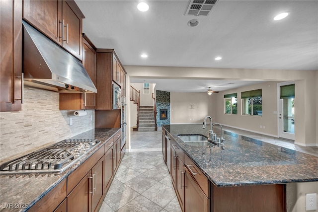 12283 Lost Treasure Ave, Las Vegas, NV 89138 - kitchen featuring an island with sink, under cabinet range hood, tasteful backsplash, a sink, and appliances with stainless steel finishes