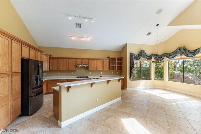 812 Eaglewood Dr, Las Vegas, NV 89144 - kitchen with fridge with ice dispenser, vaulted ceiling, light countertops, a kitchen breakfast bar, and light tile patterned floors