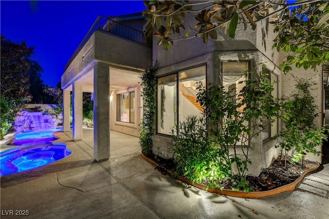 812 Eaglewood Dr, Las Vegas, NV 89144 - property exterior at twilight with a patio, a pool with connected hot tub, a balcony, and stucco siding