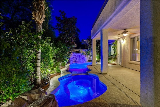 812 Eaglewood Dr, Las Vegas, NV 89144 - pool at night featuring ceiling fan, a patio area, a pool with connected hot tub, and a fenced backyard