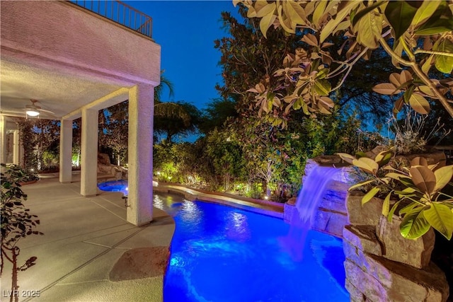 812 Eaglewood Dr, Las Vegas, NV 89144 - pool at night featuring a ceiling fan, an outdoor pool, and a patio