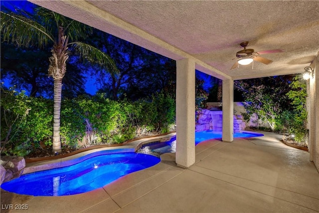 812 Eaglewood Dr, Las Vegas, NV 89144 - pool at night featuring ceiling fan, a patio, and a pool with connected hot tub