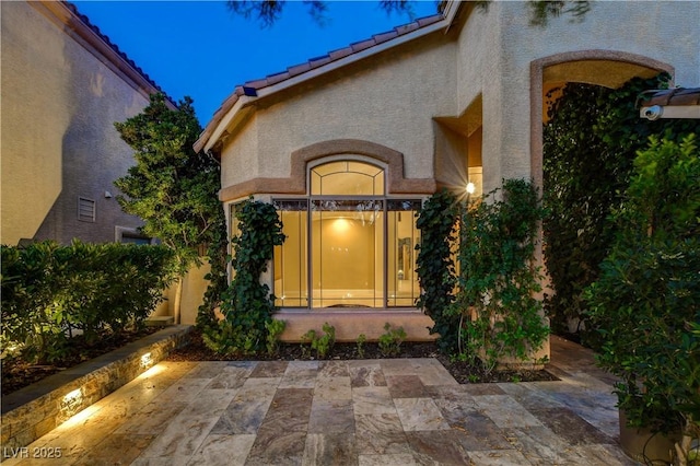 812 Eaglewood Dr, Las Vegas, NV 89144 - view of exterior entry with a patio, stucco siding, and a tile roof