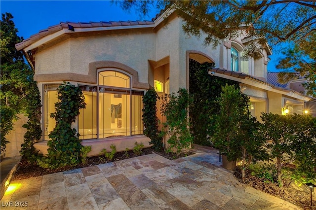 812 Eaglewood Dr, Las Vegas, NV 89144 - view of exterior entry featuring a patio, stucco siding, and a tiled roof