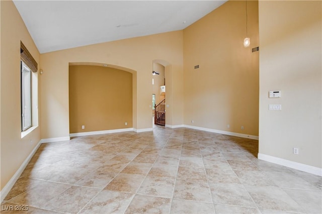 812 Eaglewood Dr, Las Vegas, NV 89144 - unfurnished room featuring arched walkways, light tile patterned flooring, stairs, and high vaulted ceiling