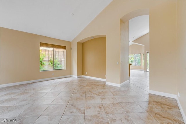 812 Eaglewood Dr, Las Vegas, NV 89144 - spare room featuring healthy amount of natural light, arched walkways, high vaulted ceiling, and light tile patterned floors