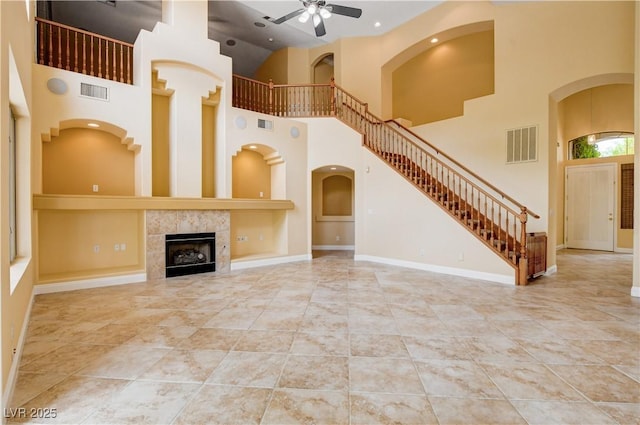812 Eaglewood Dr, Las Vegas, NV 89144 - unfurnished living room featuring a ceiling fan, a high ceiling, stairway, recessed lighting, and a tile fireplace