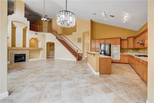 812 Eaglewood Dr, Las Vegas, NV 89144 - kitchen with stainless steel fridge with ice dispenser, white double oven, gas cooktop, arched walkways, and open floor plan