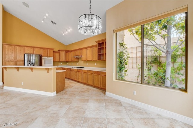 812 Eaglewood Dr, Las Vegas, NV 89144 - kitchen featuring stainless steel refrigerator with ice dispenser, white oven, light countertops, plenty of natural light, and high vaulted ceiling
