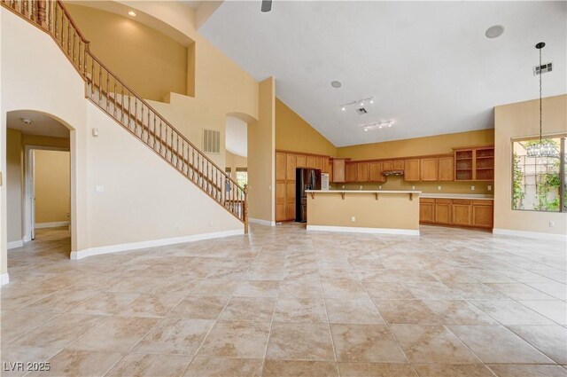 812 Eaglewood Dr, Las Vegas, NV 89144 - unfurnished living room featuring high vaulted ceiling, stairway, light tile patterned flooring, a chandelier, and arched walkways