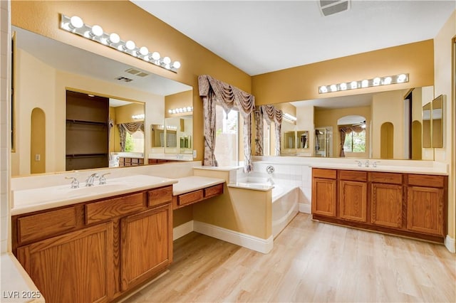 812 Eaglewood Dr, Las Vegas, NV 89144 - bathroom with wood finished floors, vanity, a garden tub, and a spacious closet