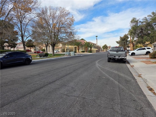 view of street with street lighting, sidewalks, a residential view, and curbs