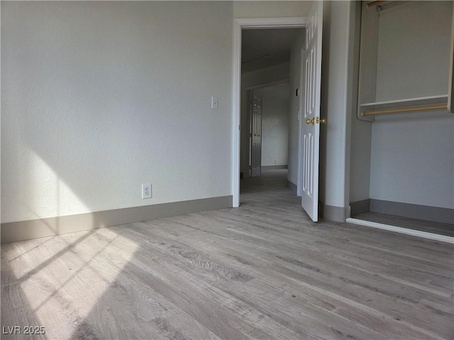 unfurnished bedroom with wood finished floors and baseboards