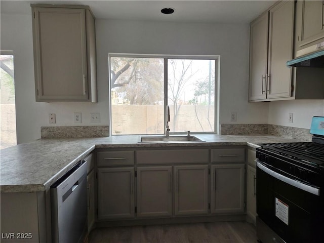 kitchen featuring gas stove, a wealth of natural light, under cabinet range hood, dishwasher, and a sink
