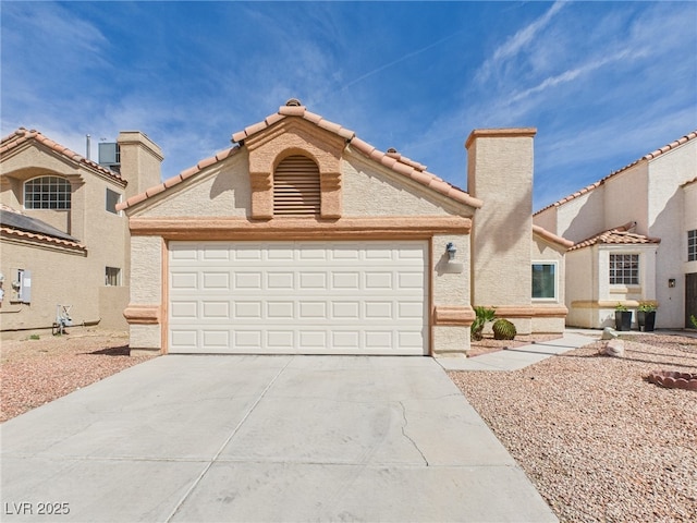 mediterranean / spanish-style home featuring a garage, driveway, and a tile roof