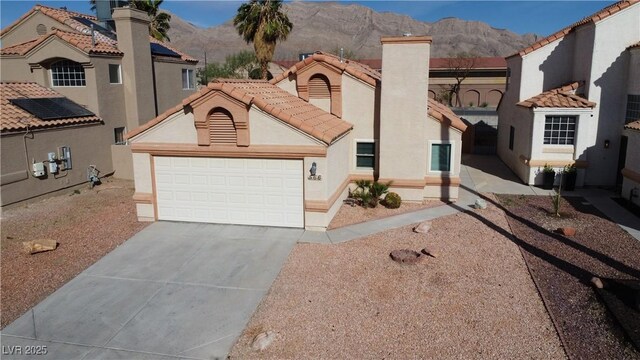 mediterranean / spanish-style house with concrete driveway, stucco siding, a mountain view, and a garage