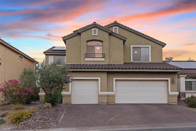 640 Finch Island Ave, Henderson, NV 89015 - view of front of house featuring stucco siding, an attached garage, solar panels, and aphalt driveway
