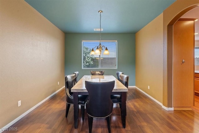 640 Finch Island Ave, Henderson, NV 89015 - dining area featuring dark wood-style flooring, arched walkways, baseboards, and a notable chandelier