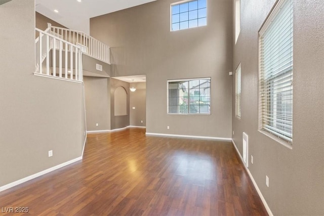 640 Finch Island Ave, Henderson, NV 89015 - unfurnished living room with plenty of natural light, a high ceiling, and wood finished floors