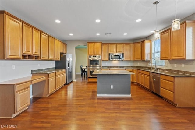 640 Finch Island Ave, Henderson, NV 89015 - kitchen with a kitchen island, dark wood-type flooring, arched walkways, a sink, and appliances with stainless steel finishes