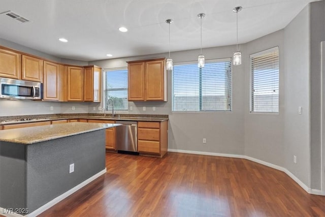 640 Finch Island Ave, Henderson, NV 89015 - kitchen with baseboards, dark wood finished floors, appliances with stainless steel finishes, and decorative light fixtures