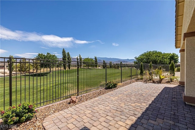 view of patio with a mountain view and a fenced backyard